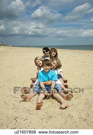 Children sitting together on beach View Large Photo Image Stock Photo - Children sitting together on beach. Fotosearch