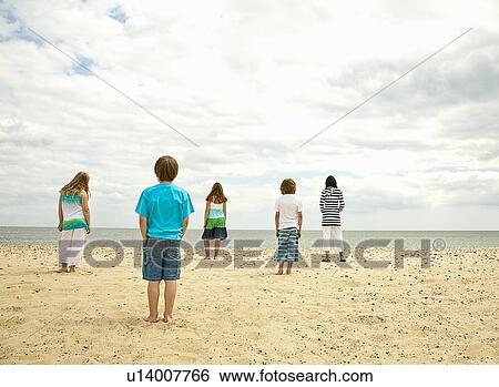 Children standing on empty beach View Large Photo Image Stock Photograph - Children standing on empty beach. Fotosearch