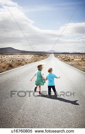 Stock Photography - Children walking on paved rural road. Fotosearch