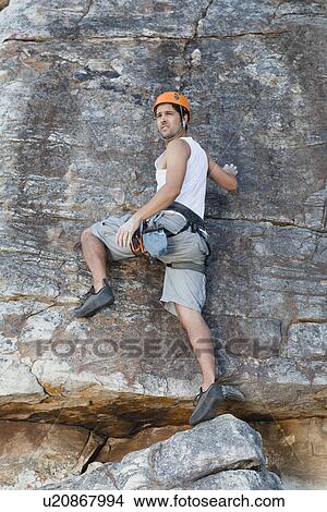 Picture - Climber scaling steep rock face. Fotosearch