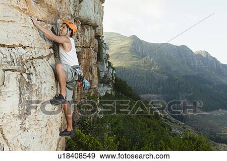 Stock Photo - Climber scaling steep rock face. Fotosearch