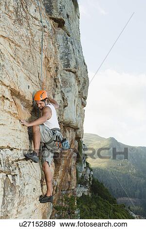 Climber scaling steep rock face View Large Photo Image Stock Photo - Climber scaling steep rock face. Fotosearch