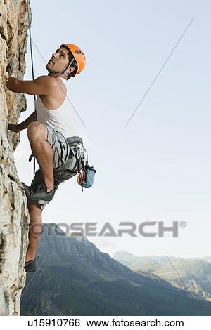 Climber scaling steep rock face View Large Photo Image Stock Photograph - Climber scaling steep rock face. Fotosearch