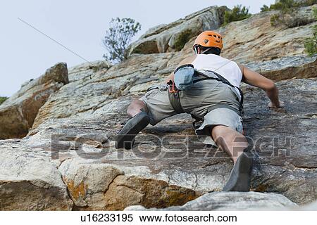 Climber scaling steep rock face View Large Photo Image Stock Photography - Climber scaling steep rock face. Fotosearch