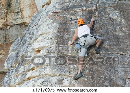 Climber scaling steep rock face View Large Photo Image Stock Photography - Climber scaling steep rock face. Fotosearch