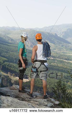 Stock Image - Climbers overlooking rural valley. Fotosearch