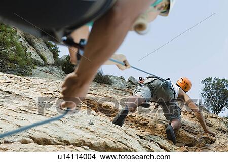 Picture - Climbers scaling steep rock face. Fotosearch