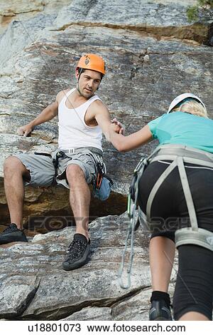 Climbers scaling steep rock face View Large Photo Image Stock Image - Climbers scaling steep rock face. Fotosearch