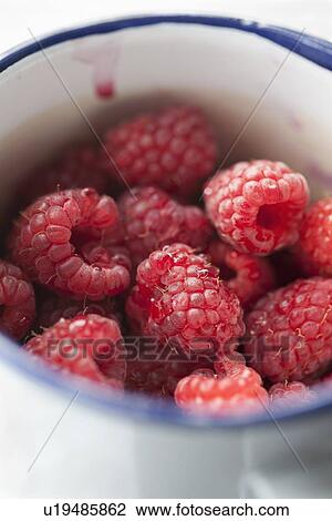 Stock Image - Close up of bowl of raspberries. Fotosearch