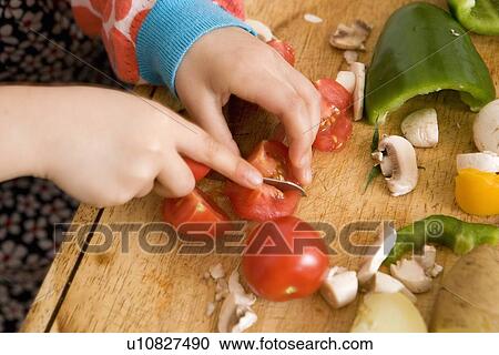 Close up of child slicing vegetables View Large Photo Image Stock Image - Close up of child slicing vegetables. Fotosearch