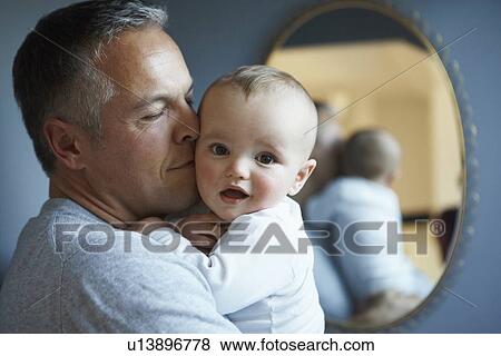 Stock Photo - Close up of father kissing baby. Fotosearch