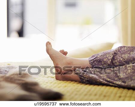 Stock Photo - Close up of girls feet on bed. Fotosearch