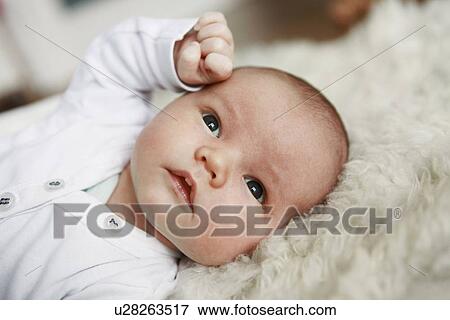 Stock Photo - Close up of infant laying on rug. Fotosearch