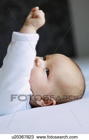 Close up of infant on bed View Large Photo Image Stock Image - Close up of infant on bed. Fotosearch