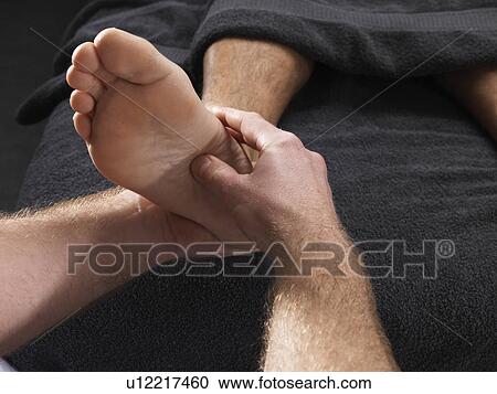 Stock Image - Close up of man having foot massage. Fotosearch