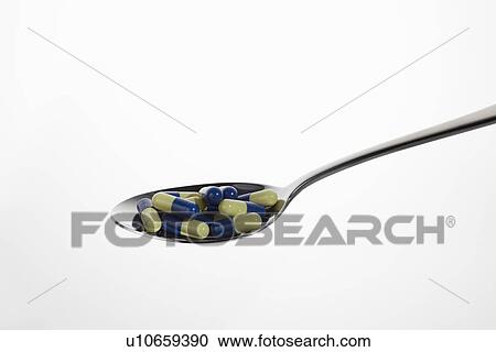 Stock Image - Close up of spoonful of pills. Fotosearch