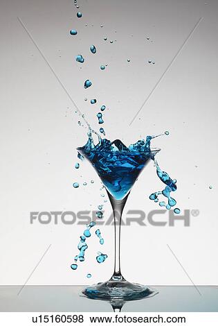 Cocktail splashing around martini glass View Large Photo Image Stock Photo - Cocktail splashing around martini glass. Fotosearch