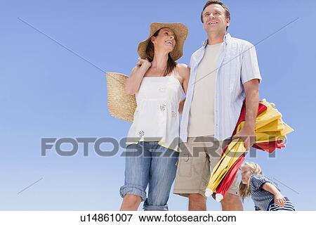 Couple carrying beach gear outdoors View Large Photo Image Stock Photo - Couple carrying beach gear outdoors. Fotosearch