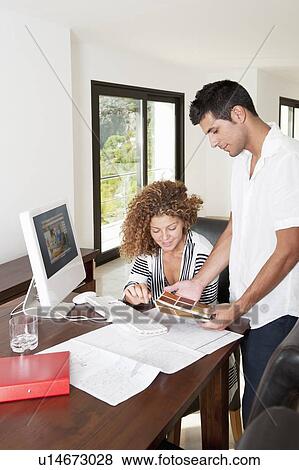 Stock Photo - Couple examining swatches at desk. Fotosearch