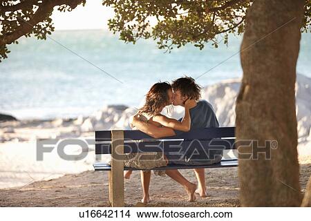 Picture - Couple kissing on park bench. Fotosearch
