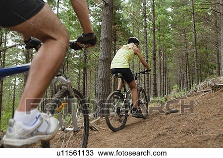 Couple mountain biking in forest View Large Photo Image Stock Image - Couple mountain biking in forest. Fotosearch