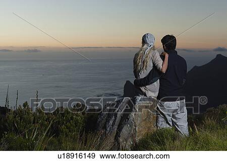 Couple overlooking coastal view View Large Photo Image Stock Photo - Couple overlooking coastal view. Fotosearch