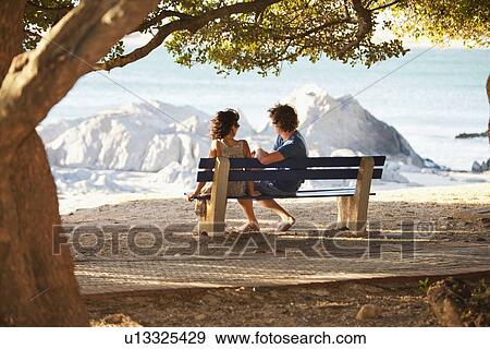 Couple overlooking view on park bench View Large Photo Image Stock Photo - Couple overlooking view on park bench. Fotosearch