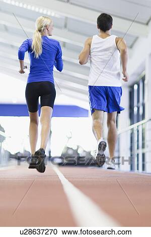 Couple running on indoor track in gym View Large Photo Image Stock Image - Couple running on indoor track in gym. Fotosearch