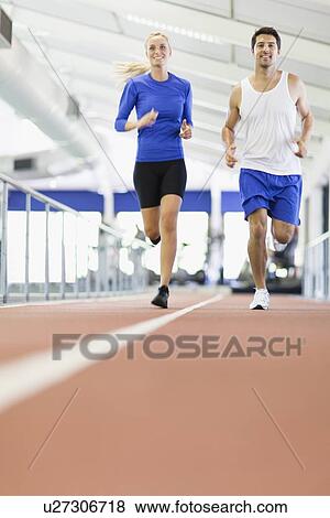 Couple running on indoor track in gym View Large Photo Image Stock Photo - Couple running on indoor track in gym. Fotosearch