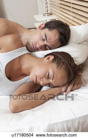 Picture - Couple sleeping in bed together. Fotosearch