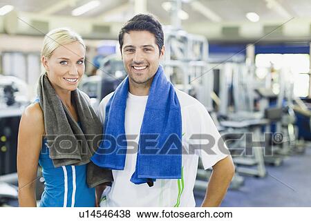 Couple smiling together in gym View Large Photo Image Stock Photo - Couple smiling together in gym. Fotosearch