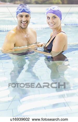 Stock Image - Couple swimming together in pool. Fotosearch