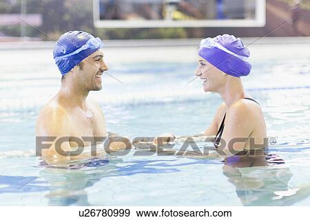 Stock Photo - Couple swimming together in pool. Fotosearch