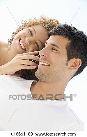 Stock Photo - Couple talking on cell phone together. Fotosearch