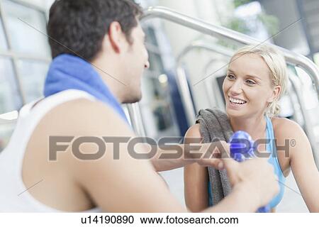 Stock Image - Couple talking on gym steps. Fotosearch