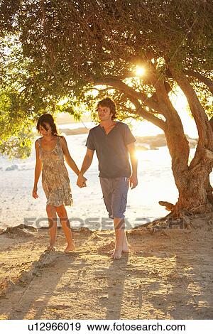 Couple walking barefoot in park View Large Photo Image Stock Photo - Couple walking barefoot in park. Fotosearch