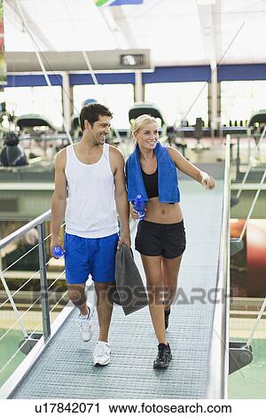 Stock Image - Couple walking together in gym. Fotosearch