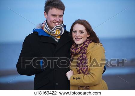 Stock Image - Couple walking together on beach. Fotosearch