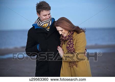 Stock Image - Couple walking together on beach. Fotosearch