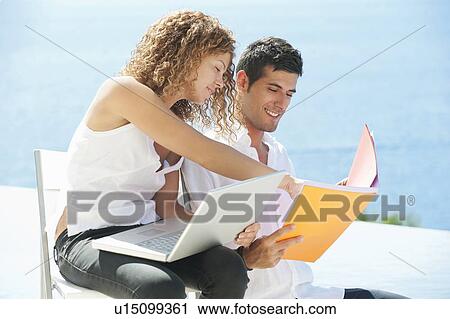 Stock Image - Couple working together outdoors. Fotosearch