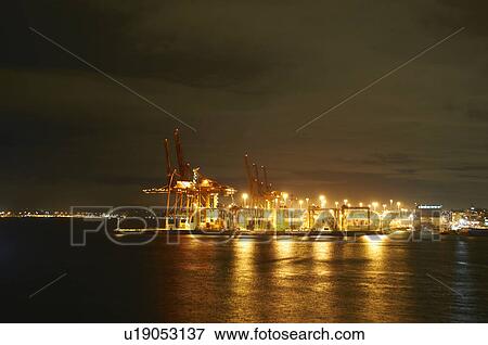Cranes in shipyard lit up at night View Large Photo Image Stock Photo - Cranes in shipyard lit up at night. Fotosearch