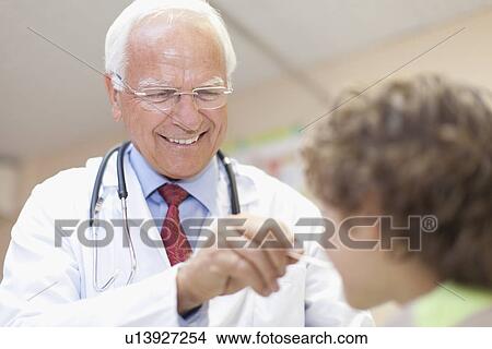 Doctor examining boy in office View Large Photo Image Picture - Doctor examining boy in office. Fotosearch