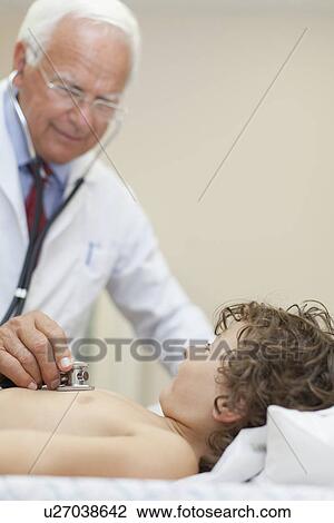 Doctor examining boy in office View Large Photo Image Stock Image - Doctor examining boy in office. Fotosearch