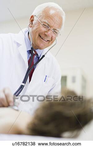 Doctor examining boy in office View Large Photo Image Stock Photo - Doctor examining boy in office. Fotosearch