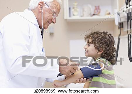 Stock Photo - Doctor examining boy in office. Fotosearch