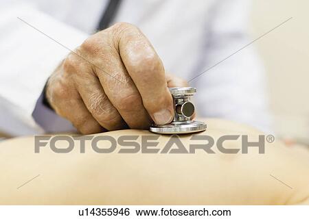 Doctor examining boy in office View Large Photo Image Stock Photograph - Doctor examining boy in office. Fotosearch