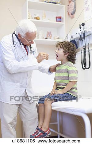 Stock Photograph - Doctor examining boy in office. Fotosearch