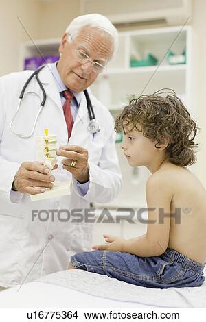 Doctor showing boy model in office View Large Photo Image Picture - Doctor showing boy model in office. Fotosearch