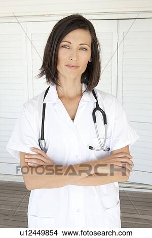 Picture - Doctor standing with arms crossed. Fotosearch