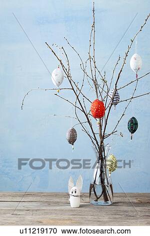 Stock Image - Egg-shaped decorations on branches. Fotosearch